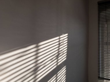 Mimari gölgeler. Güneş ışığı mimarisi, aydınlık arkaplan, beyaz doku duvarının penceresinden siyah gölge örtüsü. Model, poster, durağan, duvar sanatı, tasarım sunumu