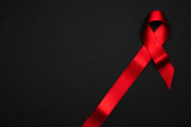 HIV desteği. HIV dünyasında siyah zemin üzerinde kırmızı kurdele sembolü. Farkındalık yardımcıları ve kanser. Yaşlanma Sağlık Ay konsepti.