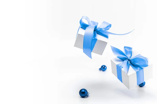 Fondo de Navidad azul. Caja de regalo blanca con cinta azul, bolas de Año Nuevo en composición navideña sobre fondo blanco para tarjeta de felicitación. Fondo de Navidad con espacio para texto. —  Fotos de Stock