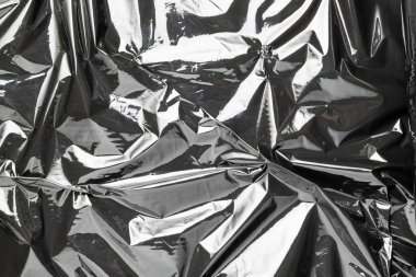 Plastik torba dokusu. Şeffaf koyu selofan arkaplanı sar. Paketleme için siyah parlak film deseni, ürün koruması