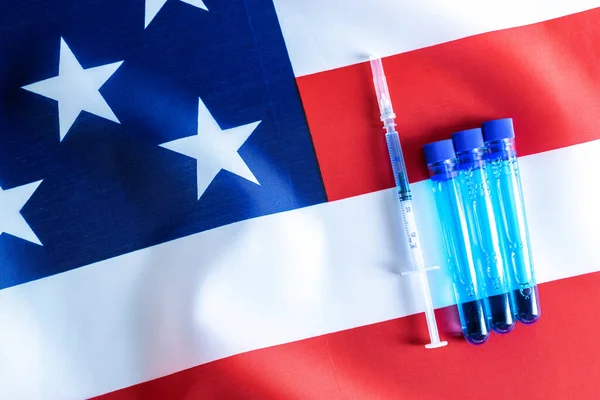 Injection usa. Medical syringe with needle for protection flu virus and coronavirus. Covid vaccine on american flag background. Concept fight against virus covid-19