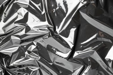 Plastik doku arka planı. Şeffaf koyu selofanı sar. Selofan siyah parlak film çantası deseni. Yaratıcı buruşuk arkaplan