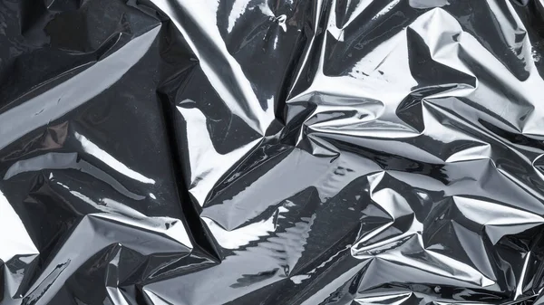 Plastik doku arka planı. Şeffaf koyu selofanı sar. Selofan siyah parlak film çantası deseni. Yaratıcı buruşuk arkaplan