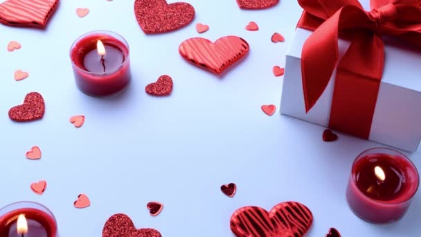 Mutlu günler. Kırmızı aşk kalpleri, romantik hediye kutusu, beyaz masada sevgililer günü mumu. Kopyalama alanı olan romantik ileti şablonu. — Stok video