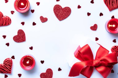 Sevgililer Günü: kırmızı aşk kalpleri, romantik hediye kutusu, beyaz arka planda mum. Kopya alanı ile romantik mesaj şablonu. Düz konum, üst görünüm, kopyalama alanı