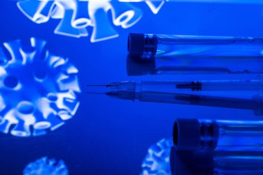 Enjeksiyon. Grip virüsünü ve koronavirüsü korumak için iğneli tıbbi şırınga. Aşı mavi renkte izole edildi. Virüse karşı kavram savaşı covid-19