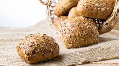 Somun ekmek. Çavdar ekmeği ve ekmek kırıntılarıyla. Buğday tohumu kulaklı bir somun taze ekmek ya da doğal pamuk arka planında çivili bitki. Biyolojik malzemeler, çok sağlıklı tohumlar.