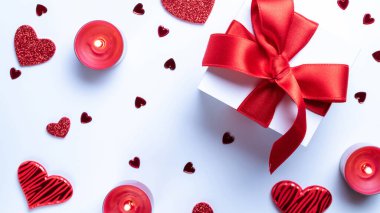 Sevgililer Günü hediye kutusu, kırmızı aşk kalpleri, beyaz arka planda romantik bir mum. Kopya alanı ile romantik mesaj şablonu. Üst Manzara. Yukarıdan görüntüle