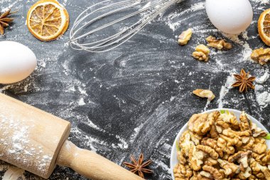 Fırın yemeği. Taze gıda malzemeleri: un, yumurta, fındık ve yıldız anason, ekmek için siyah karatahta üzerinde portakal. Fotokopi alanı olan düz bir yemek pişirme. Üst Manzara. Pişirme kavramı