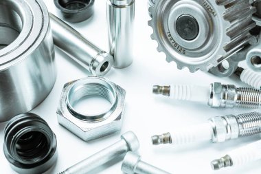 Kısmen izole. Yeni metal araba parçası seti. Otomobil motoru yedek veya otomotiv parçası beyaz arka planda izole edildi. Otomobil motoru servisi