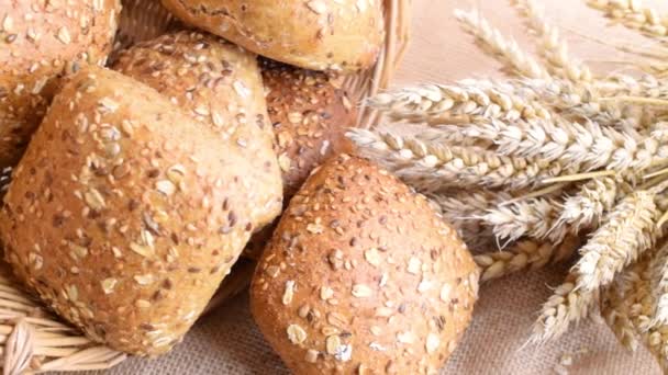 Loaf bread. Rye bakery with crusty loaves and crumbs. Fresh loaf of rustic traditional bread with wheat grain ear or spike plant on natural cotton background. Bio ingredients, very healthy seeds. — Stock Video