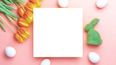 Paskalya yumurtası tavşanı. Bahar laleleriyle sepetin içinde altın, beyaz yumurta, Mutlu Paskalya dekorasyonunda pastel pembe arka planda tüyler. Düzlükte şenlik tasarımı.