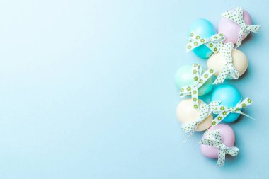 Paskalya yumurtaları izole. Mutlu Paskalya dekorasyonunda pastel mavisi arka planda bant şeritli renkli yumurta. Düz yatış, üst görünüm