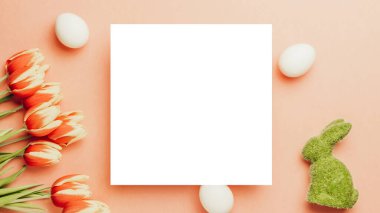 Paskalya geçmişi. Bahar laleleriyle sepetin içinde altın, beyaz yumurta, Mutlu Paskalya dekorasyonunda pastel pembe arka planda tüyler. Bahar tatili üst görünüm kavramı