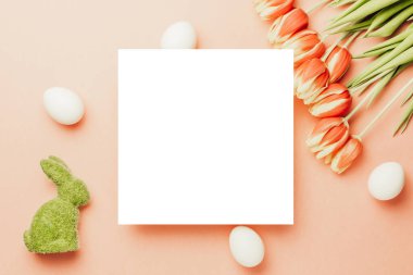 Paskalya yumurtaları izole. Bahar laleli altın, beyaz yumurta sepeti, Mutlu Paskalya dekorasyonunda pastel pembe arka planda beyaz tüyler. Düz yatış, üst görünüm
