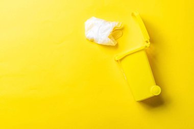 Çöp geri dönüşümü. Çöp konteynırı çöp atmak ve çevreyi korumak için. Sarı arka planda izole edilmiş plastik çöpleri geri dönüşüm için sarı çöp kutusu