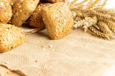 Ev yapımı ekmek. Çavdar ekmeği ve ekmek kırıntılarıyla. Buğday taneli taze köy ekmeği ya da doğal pamuk arka planında dikenli bitki. Fırın ürün etiketi için tasarım ögesi