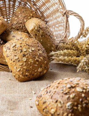 Baget ekmeği. Çavdar ekmeği ve ekmek kırıntılarıyla. Buğday tohumu kulaklı bir somun taze ekmek ya da doğal pamuk arka planında çivili bitki. Konsept - Evde Yemek Pişirme