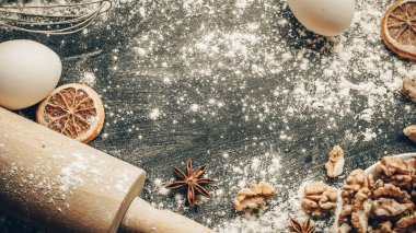 Fırın ürünleri. Yemek malzemeleri: un, yumurta, fındık ve yıldız anason, pasta için koyu masa arkası portakalı. Yukarıdan çekilen hayat, yukarıdan bakıldığında, düzdür.