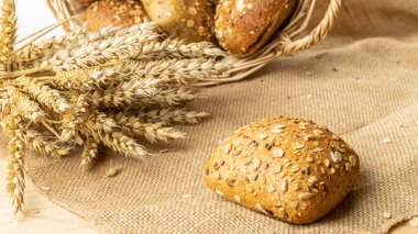 Ev yapımı ekmek. Çavdar ekmeği ve ekmek kırıntılarıyla. Buğday taneli taze köy ekmeği ya da doğal pamuk arka planında dikenli bitki. Fırın ürün etiketi için tasarım ögesi