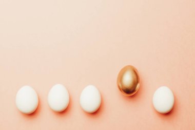 Paskalya geçmişi. Mutlu Paskalya dekorasyonunda pastel pembe arka planda altın, beyaz renkli yumurta. Bahar tatili üst görünüm kavramı