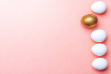 Paskalya mesajı. Mutlu Paskalya dekorasyonunda pastel pembe arka planda altın, beyaz renkli yumurta. Folyo minimalist yumurta tasarımı, modern üst görünüm şablonu