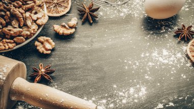 Fırın ürünleri. Yemek malzemeleri: un, yumurta, fındık ve yıldız anason, pasta için koyu masa arkası portakalı. Yukarıdan çekilen hayat, yukarıdan bakıldığında, düzdür.