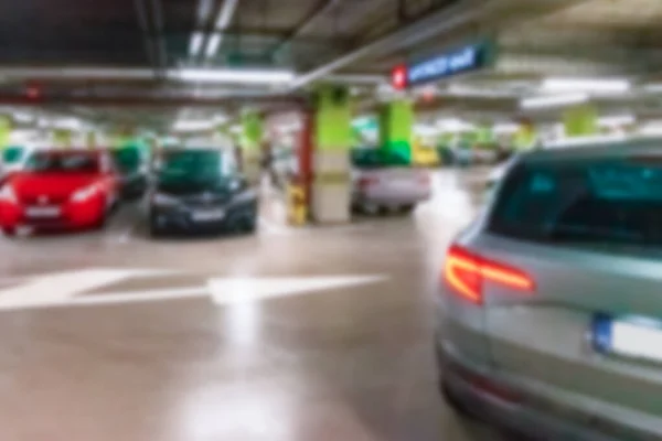 Parking lot blurred. Car lot parking space in underground city garage. Empty road asphalt background in soft focus. Ground floor for car parking