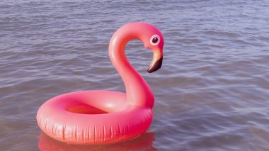 Merhaba yaz. Mavi okyanus suyunda pembe şişirilebilir flamingo. Deniz yazı plajı arka planı için. Moda yaz konsepti