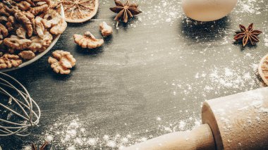 Fırın ürünleri. Yemek malzemeleri: un, yumurta, fındık ve yıldız anason, pasta için koyu masa arkası portakalı. Yukarıdan çekilen hayat, yukarıdan bakıldığında, düzdür.