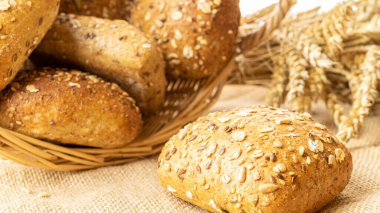 Ev yapımı ekmek. Çavdar ekmeği ve ekmek kırıntılarıyla. Buğday taneli taze köy ekmeği ya da doğal pamuk arka planında dikenli bitki. Fırın ürün etiketi için tasarım ögesi