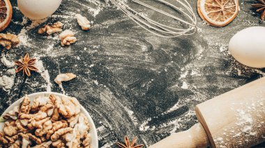 Fırın ürünleri. Yemek malzemeleri: un, yumurta, fındık ve yıldız anason, pasta için koyu masa arkası portakalı. Yukarıdan çekilen hayat, yukarıdan bakıldığında, düzdür.