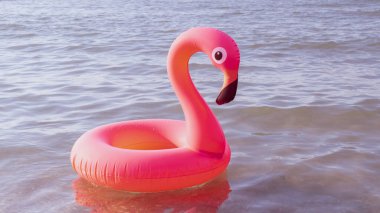 Merhaba yaz. Mavi okyanus suyunda pembe şişirilebilir flamingo. Deniz yazı plajı arka planı için. Moda yaz konsepti