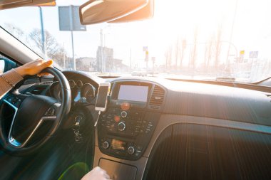 Gün batımında arabanın içinde mutlu bir sürücü. Genç bir kadın kış güneşli bir günde yolculukta iyi yolculuklar. Tatil konsepti