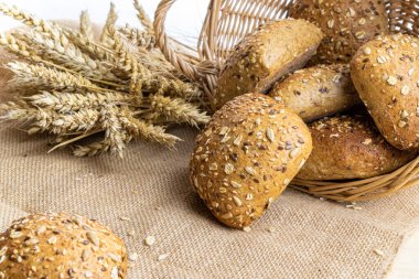 Ev yapımı ekmek. Çavdar ekmeği ve ekmek kırıntılarıyla. Buğday taneli taze köy ekmeği ya da doğal pamuk arka planında dikenli bitki. Fırın ürün etiketi için tasarım ögesi