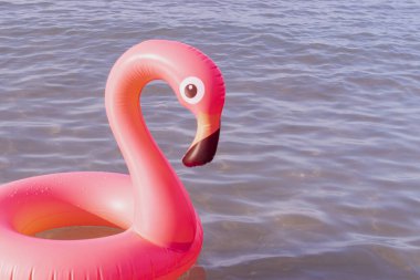 Plaj flamingosu. Yazın okyanus kıyısında mavi deniz suyunda şişme pembe flamingo. Moda yaz konsepti