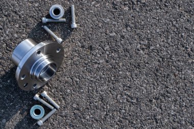 Araba parçaları. Otomobil motoru yedek veya asfalt arka planda otomotiv parçası. Yeni metal araba parçası seti. Siyah bituminimsi desenli su geçirmez.