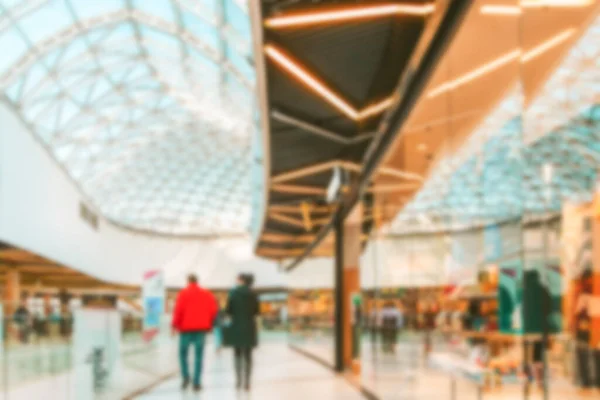 Blur background interior of retail centre store in soft focus. People shopping in modern commercial mall center. Sale, consumerism and people concept