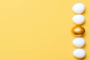 Paskalya deseni. Mutlu Paskalya dekorasyonunda pastel sarısı arka planda altın, beyaz renkli yumurta. Bahar tatili üst görünüm kavramı