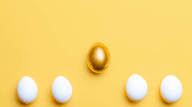 Paskalya deseni. Mutlu Paskalya dekorasyonunda pastel sarısı arka planda altın, beyaz renkli yumurta. Bahar tatili üst görünüm kavramı