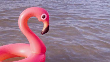 Yaz eğlencesi plajı. Yazın okyanus kıyısında mavi deniz suyunda şişme pembe flamingo. Çocuklar için komik bir oyuncak.