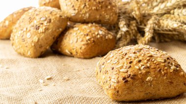 Ev yapımı ekmek. Çavdar ekmeği ve ekmek kırıntılarıyla. Buğday taneli taze köy ekmeği ya da doğal pamuk arka planında dikenli bitki. Fırın ürün etiketi için tasarım ögesi