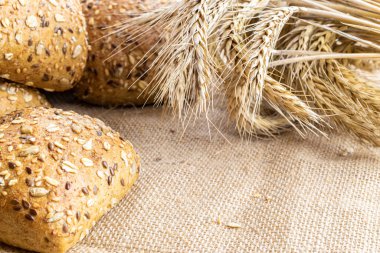 Ev yapımı ekmek. Çavdar ekmeği ve ekmek kırıntılarıyla. Buğday taneli taze köy ekmeği ya da doğal pamuk arka planında dikenli bitki. Fırın ürün etiketi için tasarım ögesi