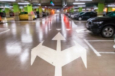 Otopark bulanıklaştı. Şehir garajındaki otoparkta. Yumuşak odak içinde boş yol asfaltı arkaplanı. Araba parkı için zemin kat.