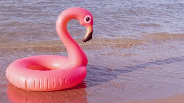 Merhaba yaz. Mavi okyanus suyunda pembe şişirilebilir flamingo. Deniz yazı plajı arka planı için. Moda yaz konsepti