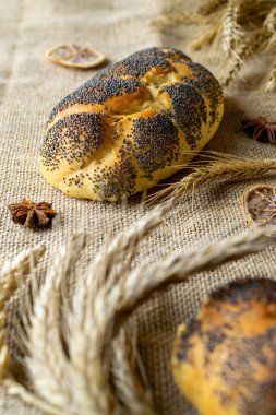 Buğday ekmeği. Haşhaş tohumlu bir somun taze ekmek keten dokusunda buğday tanesi kulağı. Çavdar ekmeği ve ekmek kırıntılarıyla. Ev yapımı pişirme.