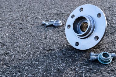 Araba aksesuarları. Yeni metal araba parçası seti. Otomobil motoru yedek veya otomotiv parçası siyah zemin asfalt dokusunda izole edilmiş. Onarım ve araç servisi