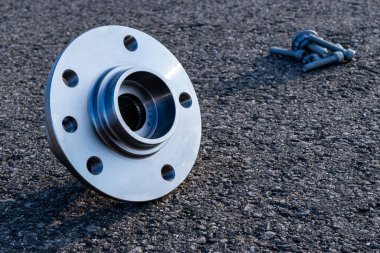 Kısmen izole. Yeni metal araba parçası seti. Otomobil motoru yedek veya otomotiv parçası siyah zemin asfalt dokusunda izole edilmiş. Asfalt koyu gri kumlu yol