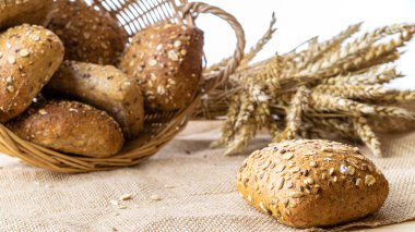 Fırın ürünleri. Çavdar ekmeği ve ekmek kırıntılarıyla. Buğday tohumu kulaklı bir somun taze ekmek ya da doğal pamuk arka planında çivili bitki. Konsept - Evde Yemek Pişirme