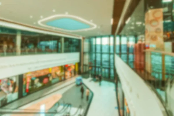 Escalator people blurred background. Interior of retail centre store in soft focus. People shopping in modern commercial mall center. Sale, consumerism and people concept